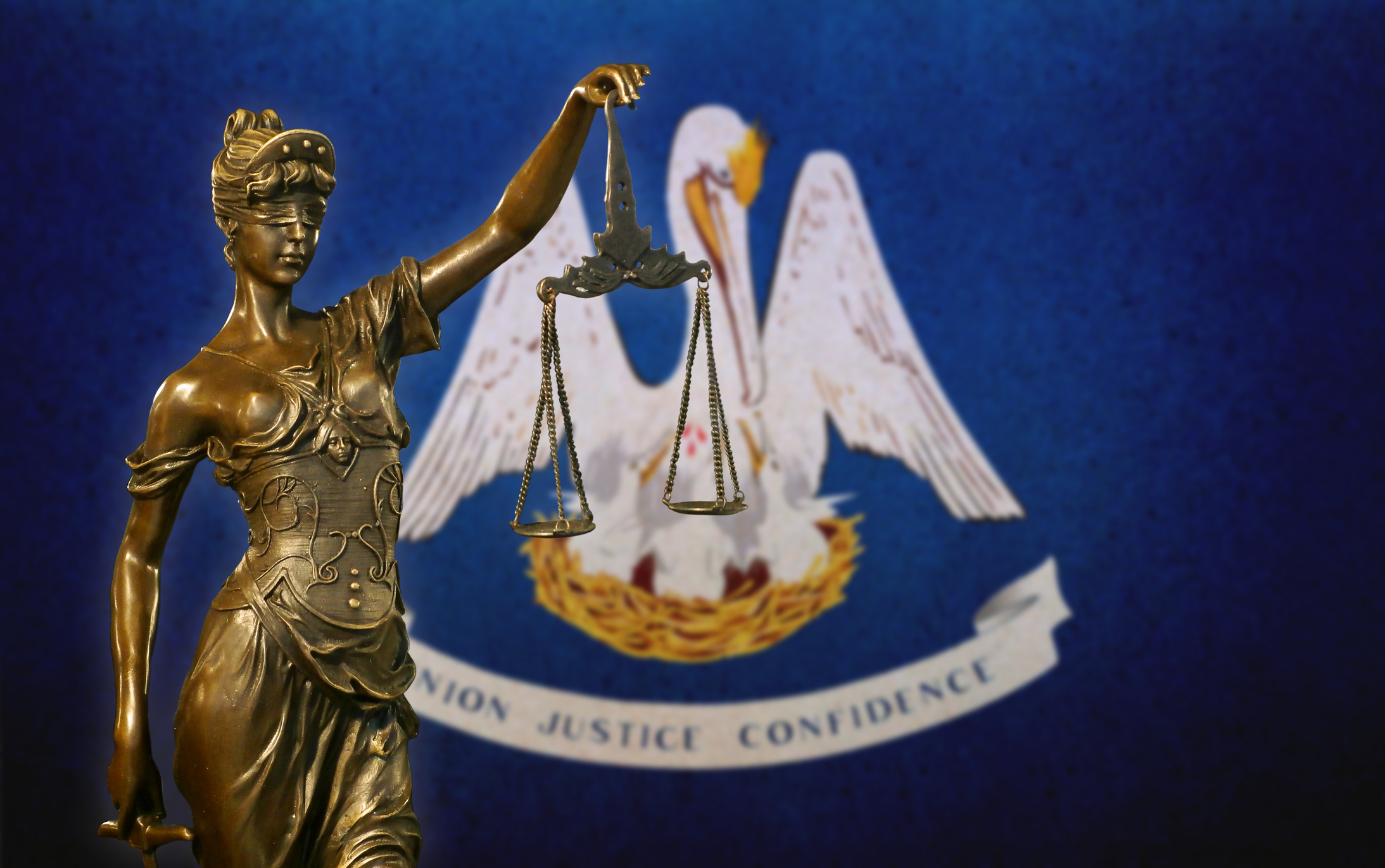 Lady Justice before a flag of Louisiana